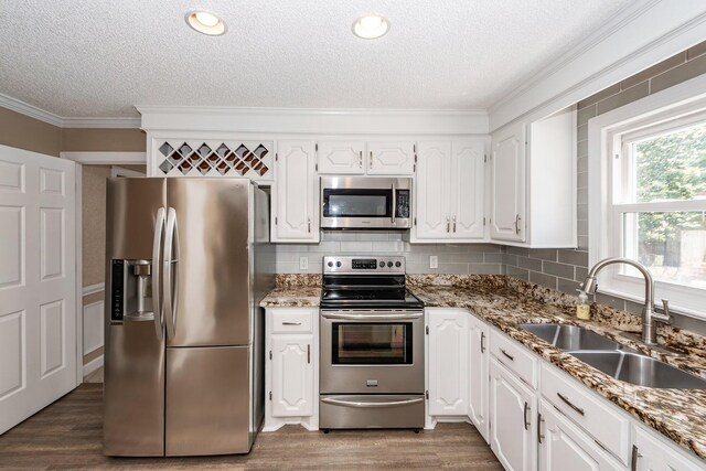 102 Six Point Ct, Goose Creek, SC 29445 - kitchen with appliances with stainless steel finishes, a sink, a textured ceiling, ornamental molding, and white cabinetry