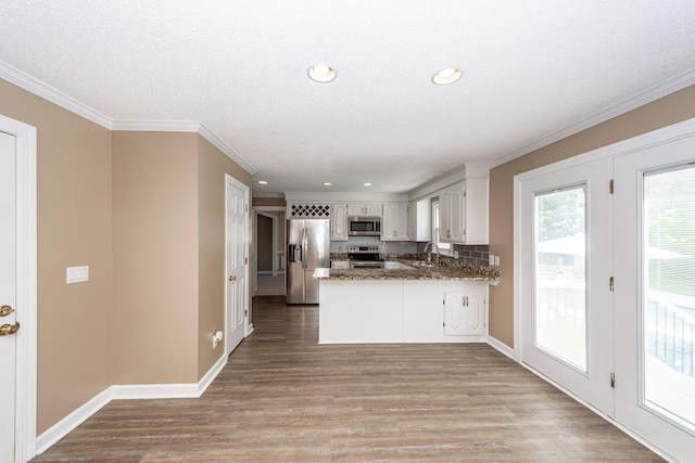 102 Six Point Ct, Goose Creek, SC 29445 - kitchen with stainless steel appliances, a peninsula, a sink, wood finished floors, and tasteful backsplash