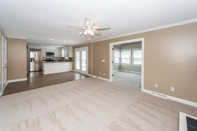 102 Six Point Ct, Goose Creek, SC 29445 - unfurnished living room featuring dark carpet, ceiling fan, plenty of natural light, a textured ceiling, and crown molding