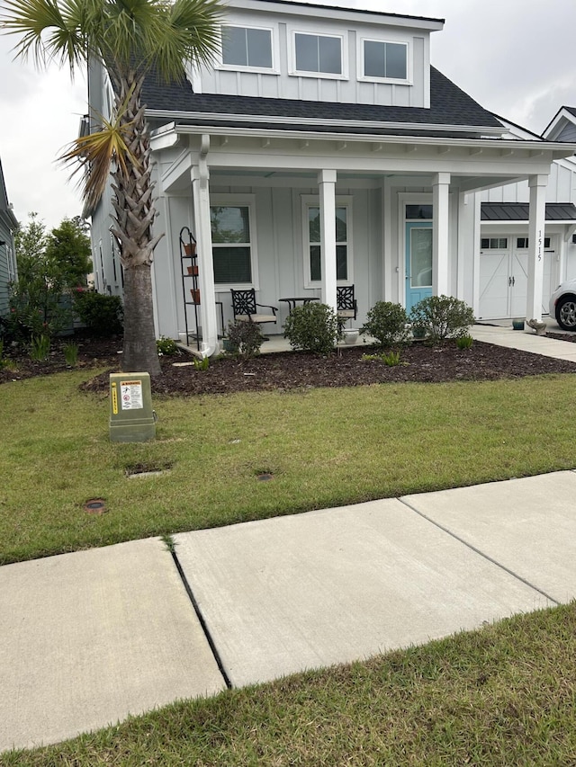 1515 Pogonia St Unit 2, Mount Pleasant, SC 29466 - view of front of house with board and batten siding, a shingled roof, a front yard, a porch, and a garage