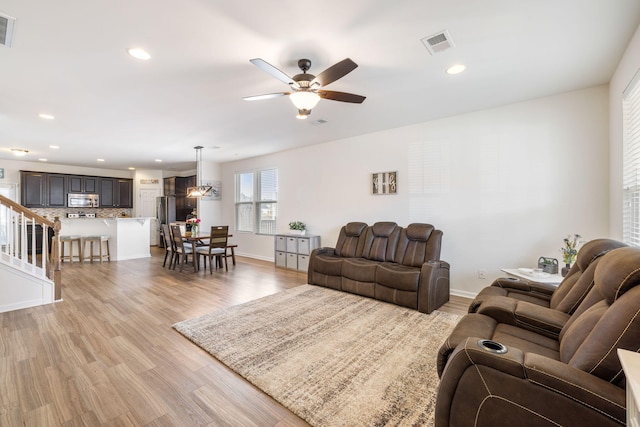 living room featuring ceiling fan and light hardwood / wood-style flooring