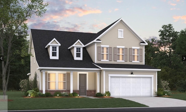 view of front of house featuring brick siding, an attached garage, driveway, and a yard