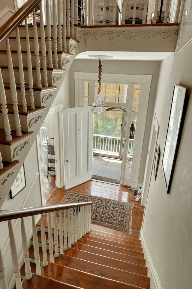 stairway with a high ceiling and hardwood / wood-style floors