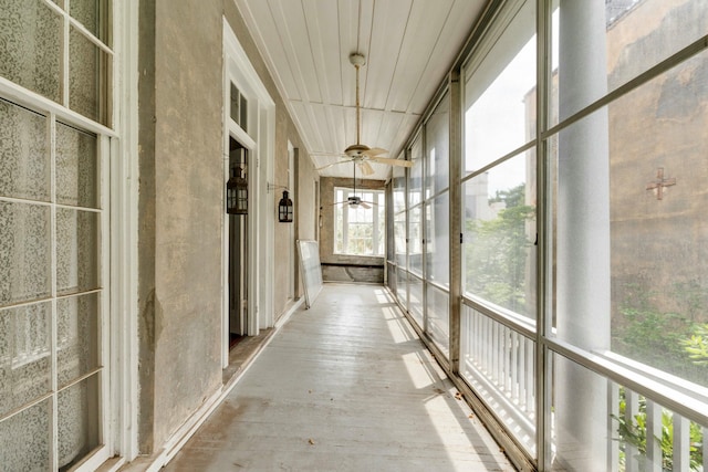 unfurnished sunroom with a ceiling fan