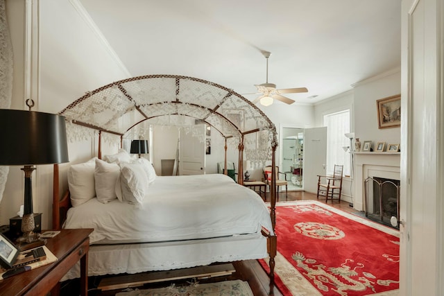 bedroom featuring crown molding, a fireplace, and wood finished floors