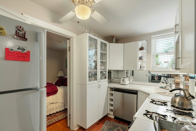 kitchen with dark wood finished floors, light countertops, glass insert cabinets, white appliances, and white cabinetry