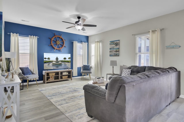 living room with ceiling fan and light hardwood / wood-style flooring