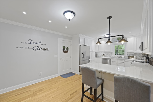 189 Fox Chase Dr, Goose Creek, SC 29445 - kitchen with appliances with stainless steel finishes, a sink, a peninsula, light countertops, and light wood-type flooring