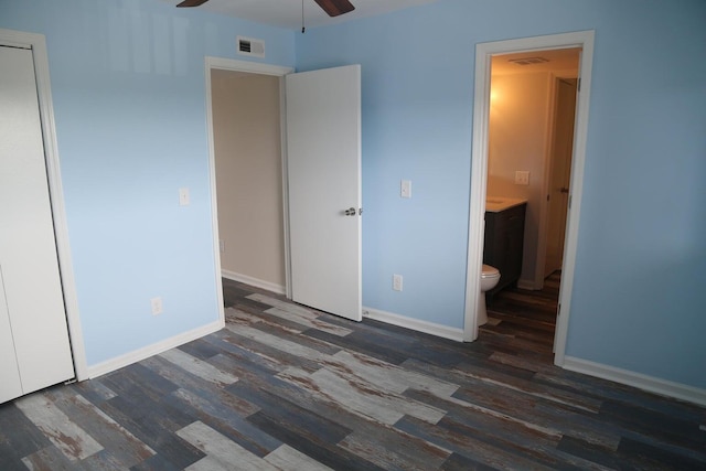 unfurnished bedroom featuring connected bathroom and dark hardwood / wood-style flooring