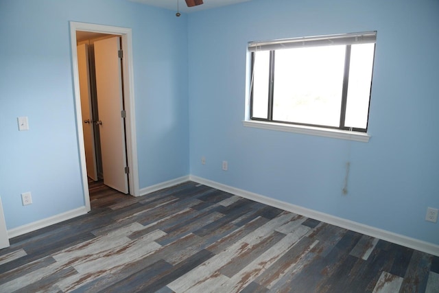 unfurnished room featuring dark hardwood / wood-style floors and ceiling fan