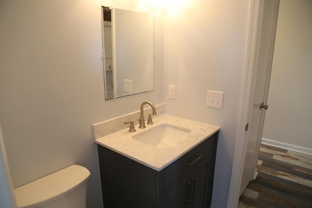 bathroom featuring hardwood / wood-style flooring, vanity, and toilet