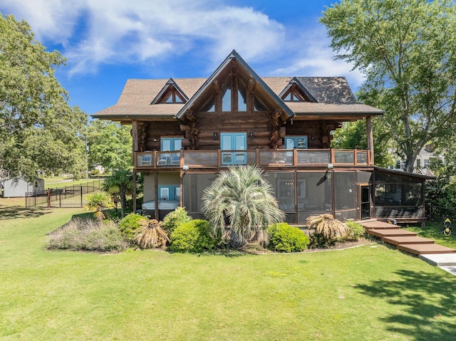 rear view of house with a balcony, a sunroom, and log exterior