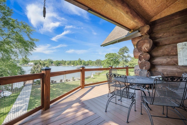 wooden deck featuring a water view, outdoor dining space, and a yard