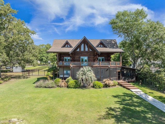 rear view of house with french doors, log exterior, a balcony, a sunroom, and an outdoor structure