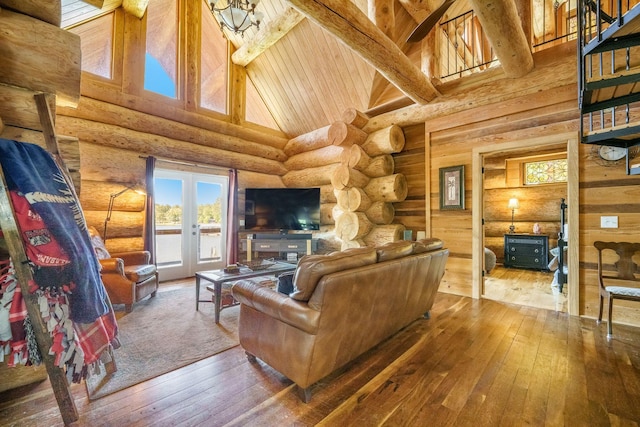 living area featuring high vaulted ceiling, hardwood / wood-style floors, log walls, beamed ceiling, and plenty of natural light