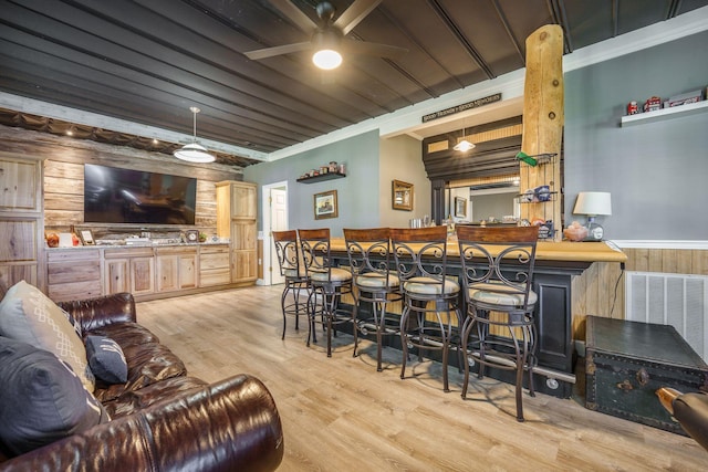 indoor bar with wooden walls, ceiling fan, wood finished floors, wainscoting, and wood ceiling