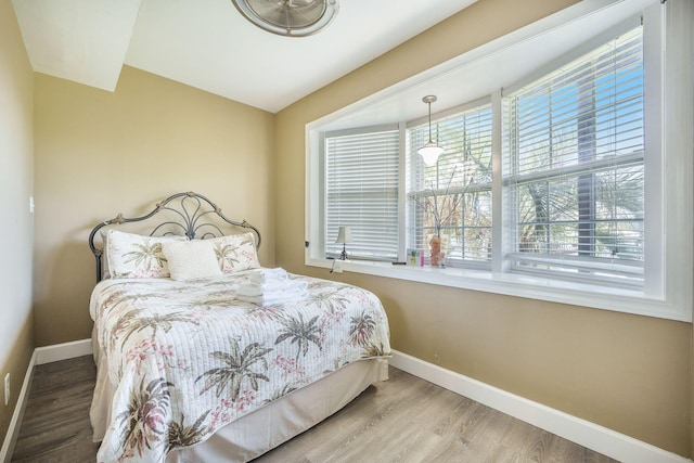 bedroom with baseboards and wood finished floors