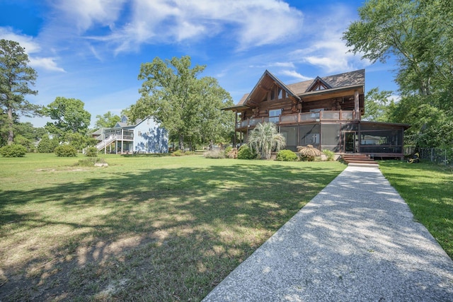 view of front of house featuring stairs, a front lawn, a balcony, and log exterior