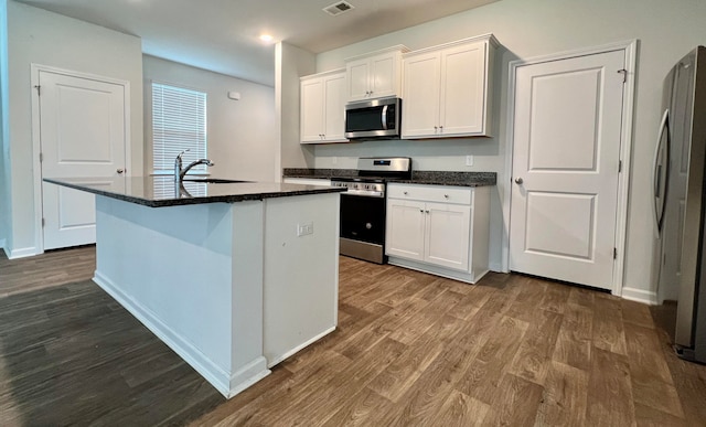 kitchen with a center island with sink, dark wood-type flooring, sink, and stainless steel appliances