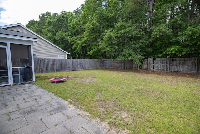 view of yard with a sunroom and a patio area