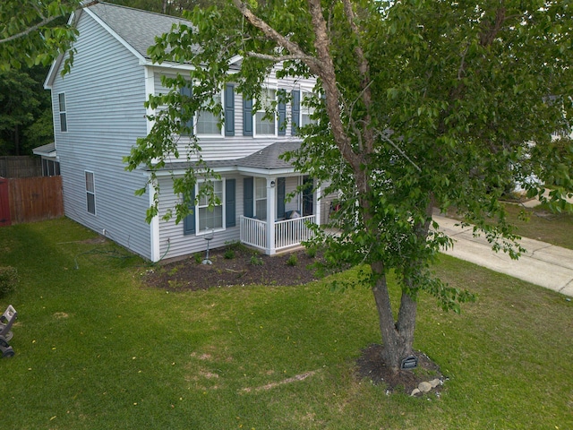 view of side of home with a shingled roof and covered porch
