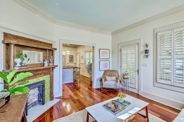 living room with ornamental molding, a high end fireplace, baseboards, and wood finished floors