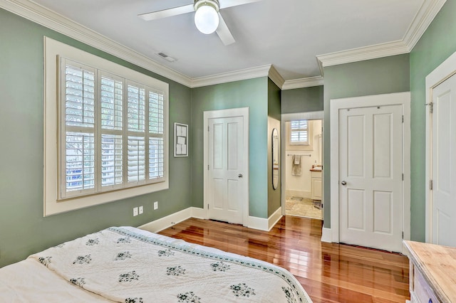 bedroom featuring wood finished floors, a ceiling fan, baseboards, visible vents, and crown molding