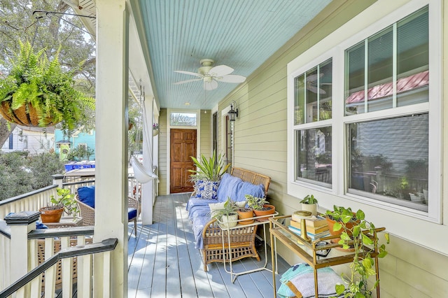 wooden deck with a ceiling fan, a porch, and an outdoor hangout area