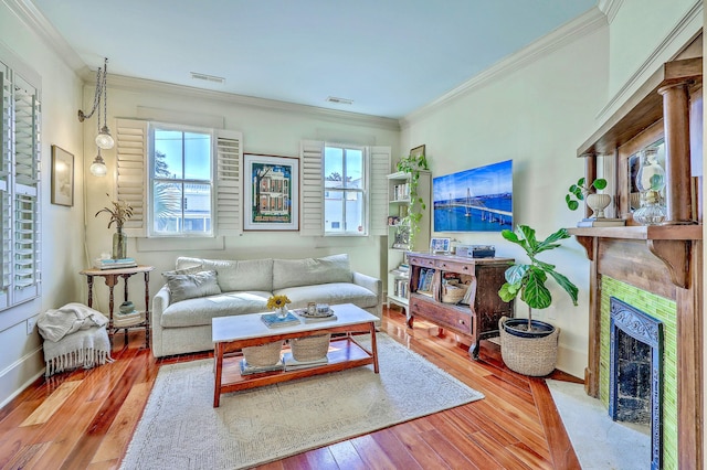 living room with wood-type flooring, visible vents, and crown molding