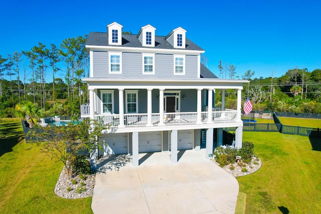 view of front facade featuring a front lawn, covered porch, and a garage