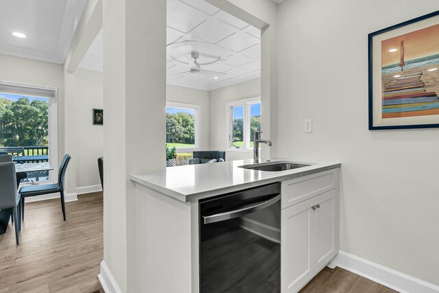 kitchen featuring dishwasher, hardwood / wood-style flooring, sink, white cabinets, and kitchen peninsula