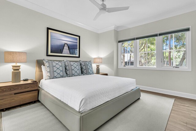 bedroom featuring ceiling fan, crown molding, and light hardwood / wood-style floors