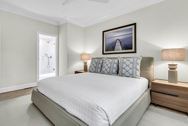 bedroom featuring ornamental molding, hardwood / wood-style flooring, ensuite bathroom, and ceiling fan