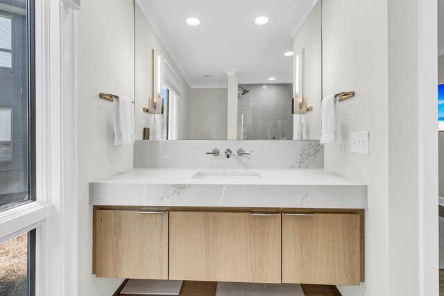 bathroom with walk in shower, vanity, and crown molding