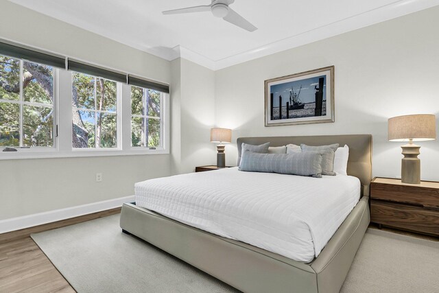 bedroom with ceiling fan, ornamental molding, and light hardwood / wood-style floors