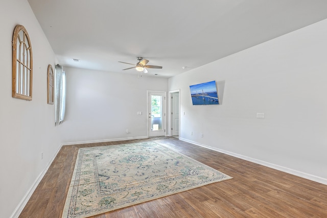 spare room with ceiling fan, wood finished floors, and baseboards