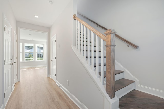 staircase with recessed lighting, baseboards, and wood finished floors