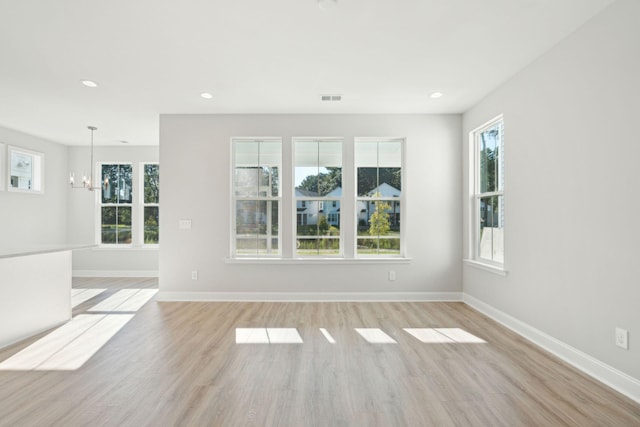 empty room with baseboards, visible vents, and light wood-style floors