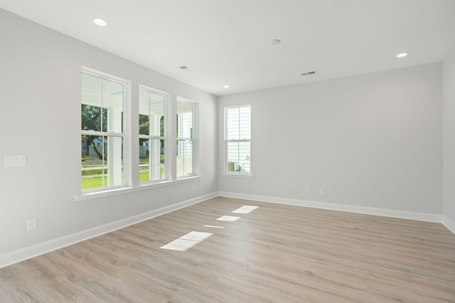 empty room with light wood-type flooring, visible vents, baseboards, and recessed lighting