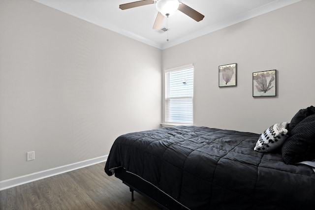 bedroom featuring wood finished floors, baseboards, crown molding, and ceiling fan