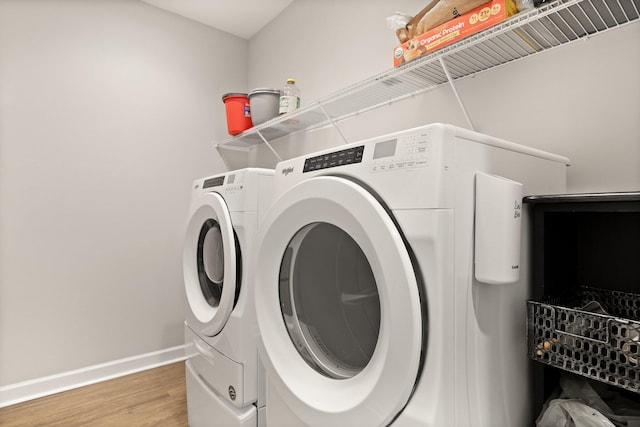 laundry room with washer and dryer, light wood-style flooring, and baseboards