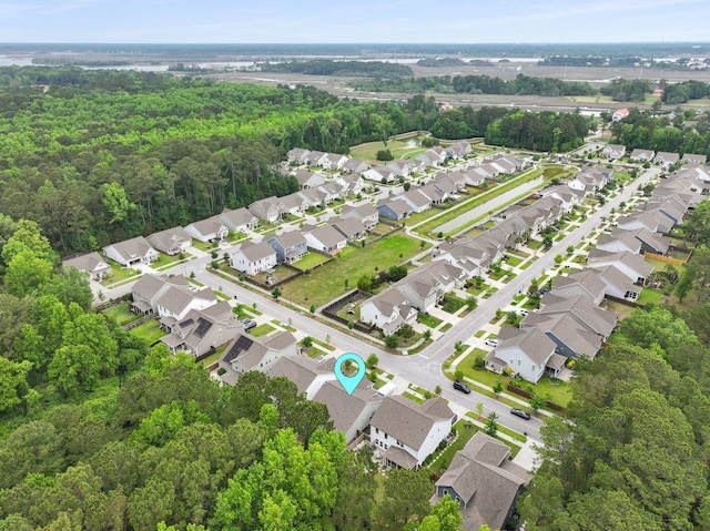 aerial overview of property's location featuring nearby suburban area and a heavily wooded area