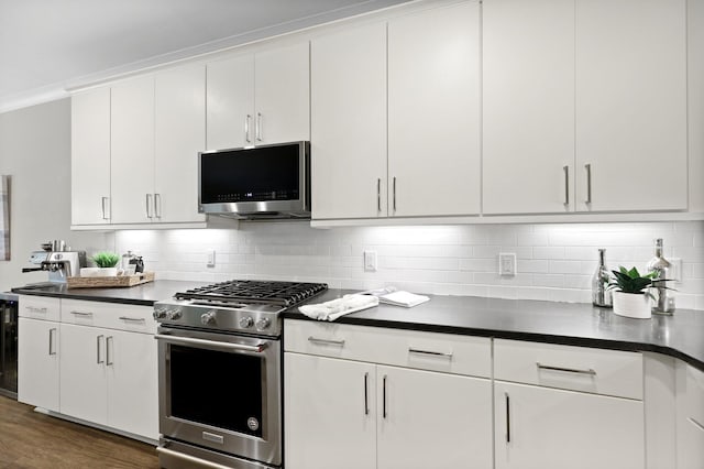 kitchen featuring appliances with stainless steel finishes, dark countertops, and white cabinetry
