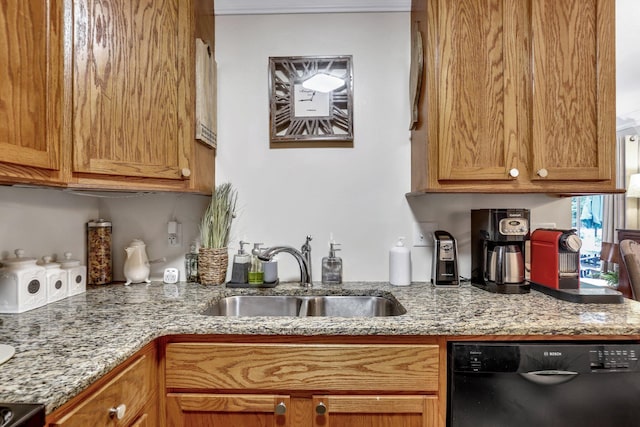 kitchen with light stone counters, dishwasher, and sink