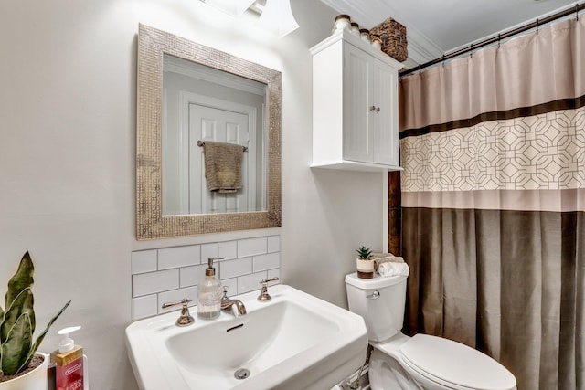 bathroom featuring ornamental molding, sink, tasteful backsplash, walk in shower, and toilet