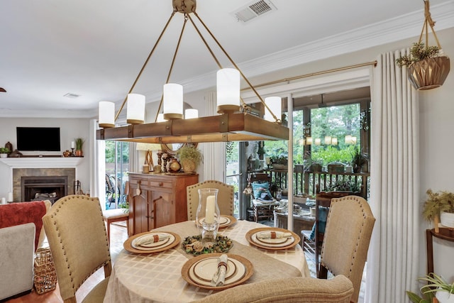 dining area featuring crown molding, a fireplace, and hardwood / wood-style flooring