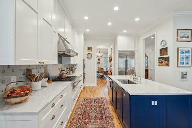 kitchen featuring light stone counters, under cabinet range hood, a sink, white cabinets, and appliances with stainless steel finishes