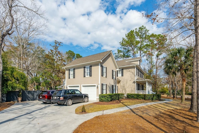 view of property exterior with driveway, a garage, and fence