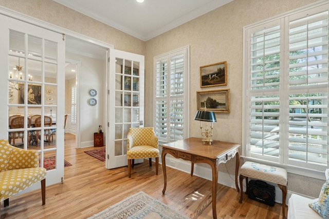 sitting room with french doors, baseboards, crown molding, and light wood finished floors