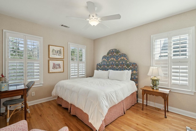 bedroom featuring light wood finished floors, baseboards, visible vents, and a ceiling fan